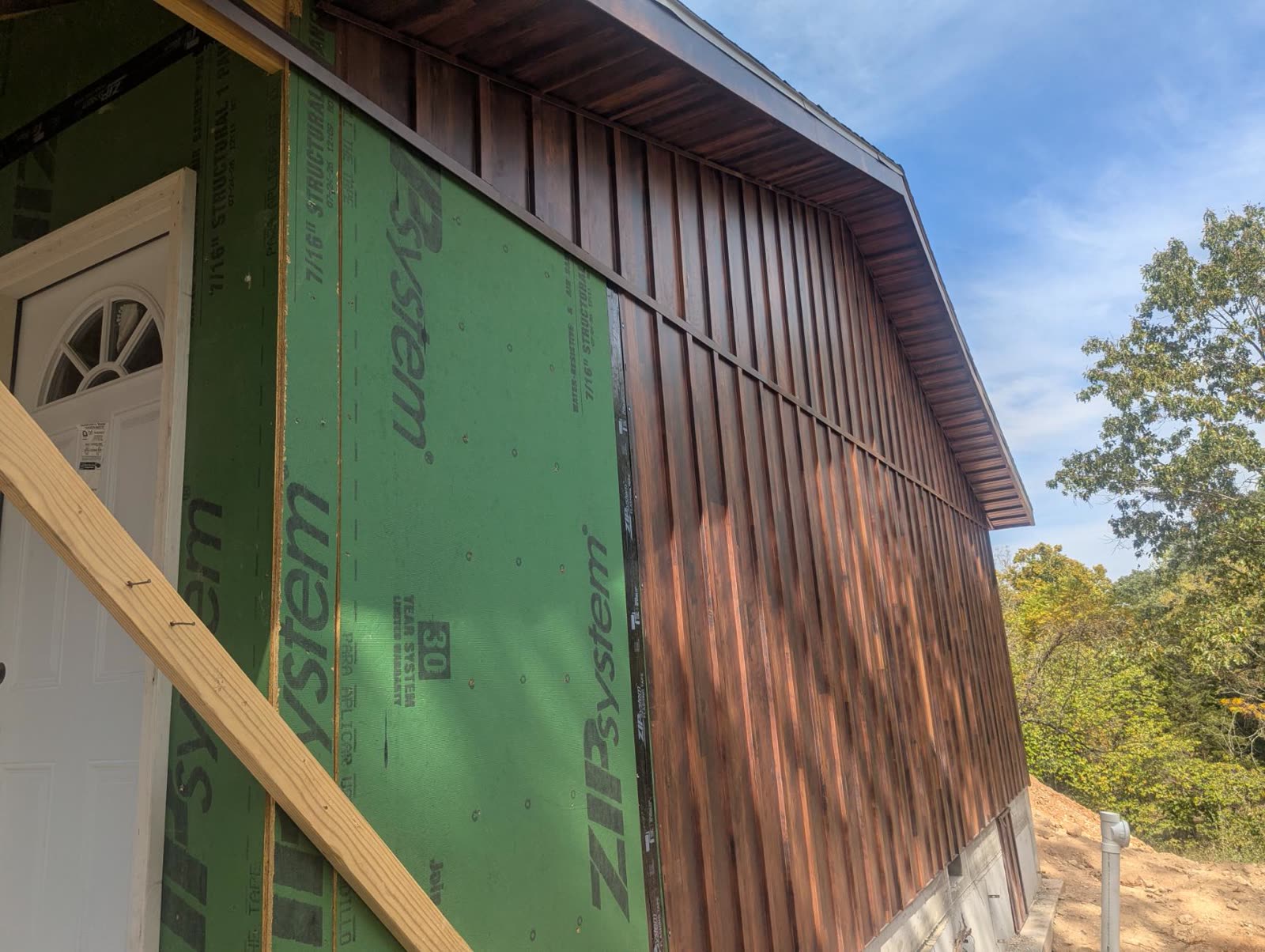 Wood siding meeting the sheathed wall beside the front door